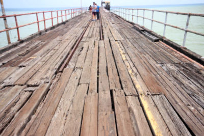 close up view of boards of Puerto Armuelles pier and people in background