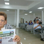 woman reading a paper and others waiting in airport