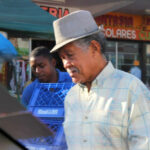 a delivery young man and old man wearing a fedora