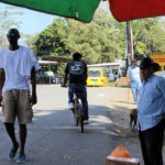 bikers, walkers, and people waiting on street in Puerto Armuelles, Panama