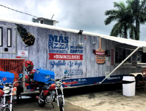 Dominos restaurant in a grey trailer, palm tree in background