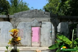 facade of a cement home with unpainted exterior and pink interior